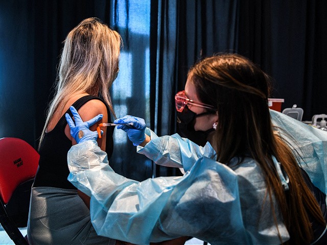 A health care worker administers a Covid-19 vaccine during a vaccination event hosted by Miami Heat at FTX Arena in Miami, on August 5, 2021. (Photo by CHANDAN KHANNA / AFP) (Photo by CHANDAN KHANNA/AFP via Getty Images)