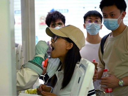 A swab sample is taken from a woman to be tested for the Covid-19 coronavirus at a hospital in Beijing on August 2, 2021, amid the country's most widespread coronavirus outbreak in months. (Photo by Noel Celis / AFP) (Photo by NOEL CELIS/AFP via Getty Images)