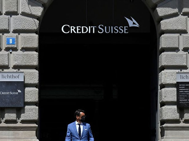 People pass by the headquarters of Swiss bank Credit Suisse in Zurich on August 9, 2021. (