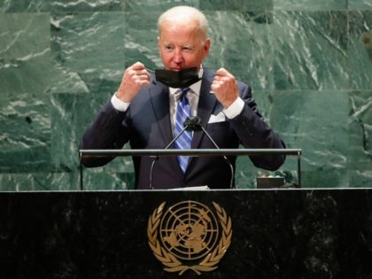 US President Joe Biden takes off his protective facemask due to the coronavirus disease (C