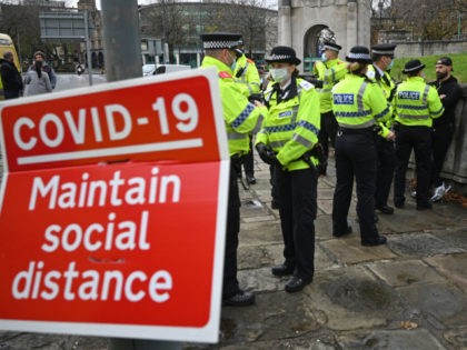 Police officers speak to protester Paul Boys (R) as they attempt to disperse an anti-vax rally and protest against vaccination and government restrictions designed to control or mitigate the spread of the novel coronavirus, including the wearing of masks and lockdowns, in Liverpool, north-west England on November 14, 2020. (Photo …