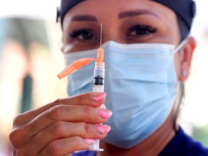 Vocational nurse Christina Garibay displays a syringe with Johnson & Johnson's Janssen Covid-19 vaccine at a Skid Row community outreach event where coronavirus vaccines and testing were offered in Los Angeles, California on August 22, 2021. (Frederick J. Brown/AFP via Getty Images)
