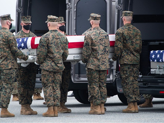 A flag-draped transfer case with the remains of a fallen service member are placed inside a transfer vehicle as US President Joe Biden attends the dignified transfer of the remains of a fallen service member at Dover Air Force Base in Dover, Delaware, August, 29, 2021, one of the 13 members of the US military killed in Afghanistan last week. - President Joe Biden prepared Sunday at a US military base to receive the remains of the 13 American service members killed in an attack in Kabul, a solemn ritual that comes amid fierce criticism of his handling of the Afghanistan crisis. Biden and his wife, Jill, both wearing black and with black face masks, first met far from the cameras with relatives of the dead in a special family center at Dover Air Force Base in Delaware.The base, on the US East Coast about two hours from Washington, is synonymous with the painful return of service members who have fallen in combat. (Photo by SAUL LOEB / AFP) (Photo by SAUL LOEB/AFP via Getty Images)