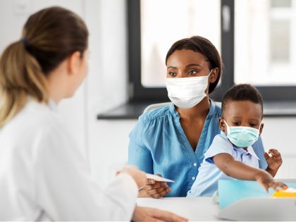mother with baby son in masks and doctor at clinic - stock photo