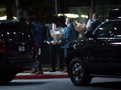 Staff carry flowers from a motorcade as US President Joe Biden and US first lady Jill Biden visit wounded troops at Walter Reed Military Medical Center in Bethesda, Maryland on September 2, 2021. (Photo by Brendan Smialowski / AFP) (Photo by BRENDAN SMIALOWSKI/AFP via Getty Images)