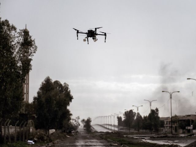 TOPSHOT - A picture taken on March 14, 2017 in the northern Iraqi city of Mosul shows a drone carrying two grenades flying in a test flight by Iraqi forces which aim to use it against Islamic State (IS) group fighters. IS have used small drones to drop explosives on …