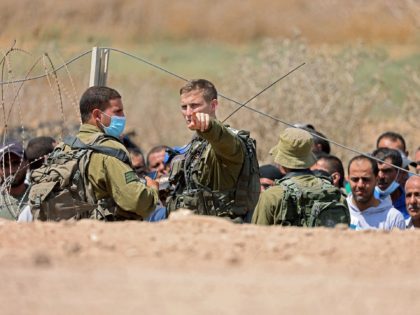 Israeli soldiers search Palestinian labourers, who work in Israel, before allowing them to cross through a hole in a security fence in the West Bank town of Jenin, on September 6, 2021, following the break out of six Palestinians from an Israeli prison. - Six Palestinians broke out of an …