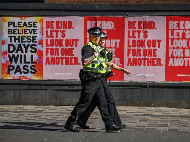 GLASGOW, SCOTLAND - MAY 06: Two police officers walk past posters on Sauchiehall Street du