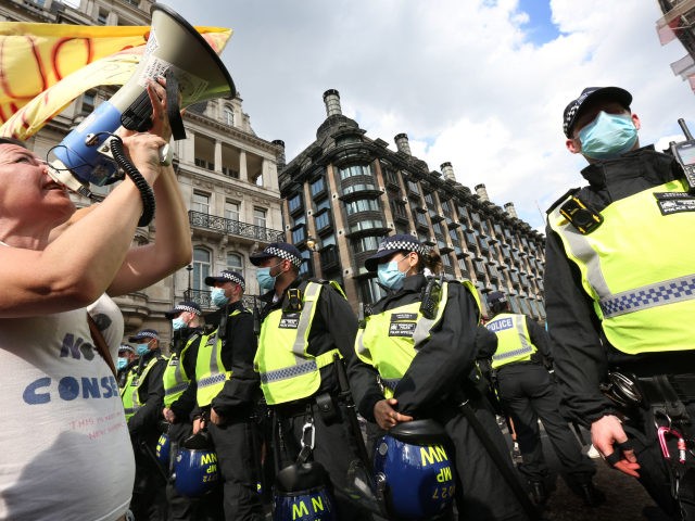 LONDON, ENGLAND - JULY 19: A protester addresses the police line through a megaphone in Parliament Square as part of a freedom demonstration on July 19, 2021 in London, England. Anti-lockdown protests have been a feature of the Coronavirus Pandemic across the UK uniting the anarchist left and anti-establishment right. …