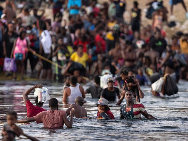 CIUDAD ACUNA, TEXAS - SEPTEMBER 19: Immigrants, mostly from Haiti gather on the bank of the Rio Grande on September 19, 2021 in Ciudad Acuna, Mexico, across the border from Del Rio, Texas. As U.S. immigration authorities began deporting immigrants back to Haiti from Del Rio, thousands more waited in …
