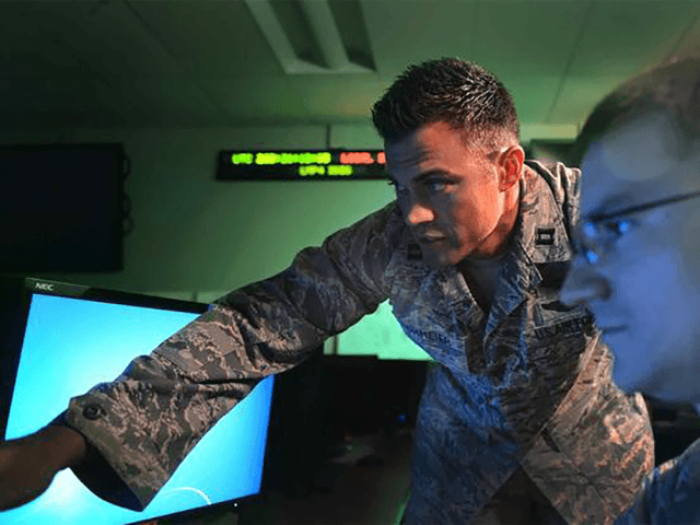 Then U.S. Air Force Capt. Matthew Lohmeier (left) instructs a trainee in the Standardized Space Trainer July 22, 2015, on Buckley Air Force Base, Colo. (U.S. Air Force/Senior Airman Darren Scott)