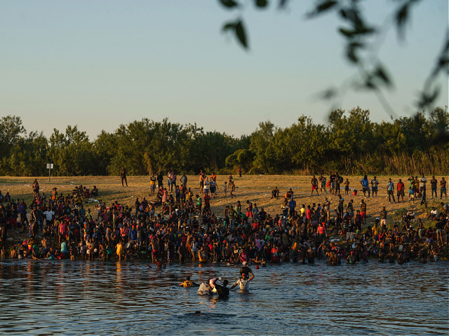Haitian migrants are pictured on the banks of the Rio Grande in Del Rio, Texas, as seen from Ciudad Acuna, Coahuila state, Mexico on September 19, 2021. - US law enforcement, trying to control the flow of migrants from crossing back and forth from Mexico, is not providing enough food and water in the encampment thus causing people to cross back and forth, whichever way they can. Thousands of migrants, many of them Haitians, are crowded under a bridge in Texas after crossing the Rio Grande river, hoping to be allowed into the country. (Photo by PAUL RATJE / AFP) (Photo by PAUL RATJE/AFP via Getty Images)