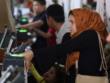 A woman gets her fingerprints read to submit her passport application at an office in Kabul on July 25, 2021. - Dozens begin lining up at the passport office in Kabul before dawn most days, and by eight in the morning the queue already stretches for a good hundred metres. …