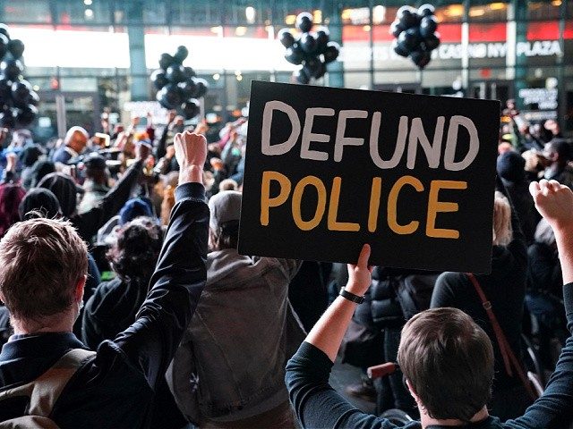 A protester holds a sign that reads “Defund Police” during a rally for the late George Floyd outside Barclays Center in New York. (AP Photo/John Minchillo, File)