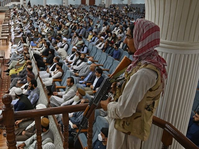 TOPSHOT - A Taliban fighter stands guard as Talibans acting Higher Education Minister Abdul Baqi Haqqani (not pictured) addresses a gathering during a consultative meeting on Taliban's general higher education policies at the Loya Jirga Hall in Kabul on August 29, 2021. - Afghan women will be allowed to study …
