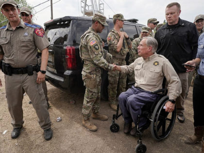 Texas Gov. Greg Abbott, right, shakes a National Guard member's hand after speaking during a news conference along the Rio Grande, Tuesday, Sept. 21, 2021, in Del Rio, Texas. The U.S. is flying Haitians camped in a Texas border town back to their homeland and blocking others from crossing the …