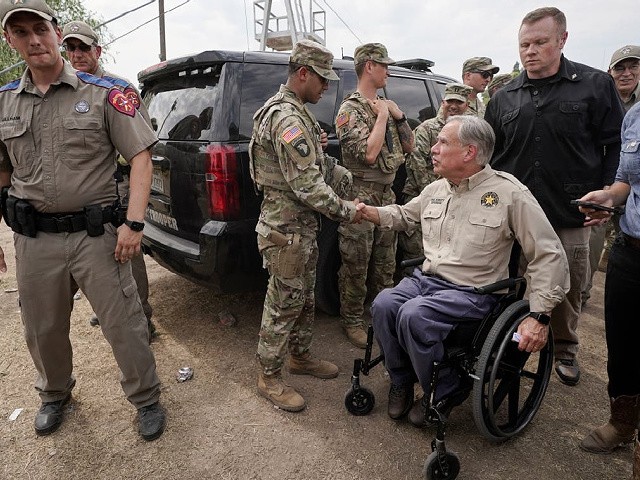 Texas Gov. Greg Abbott, right, shakes a National Guard member's hand after speaking during a news conference along the Rio Grande, Tuesday, Sept. 21, 2021, in Del Rio, Texas. The U.S. is flying Haitians camped in a Texas border town back to their homeland and blocking others from crossing the border from Mexico. (AP Photo/Julio Cortez)