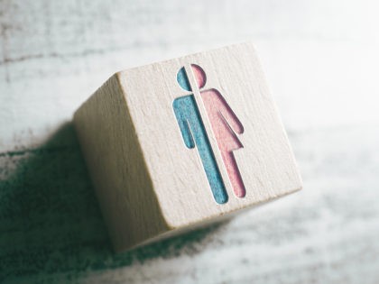 Gender Signs For Male And Female Cut In Half On A Wooden Block On A Table - stock photo