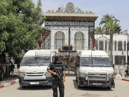 Police cars and a military armored personnel carrier block the entrance of the Tunisian parliament in Tunis, Tuesday, July 27, 2021. The Ennahda party, has called for dialogue, following President Kais Saeid's sacking of the prime minister and suspension of parliament on Sunday. (AP Photo/Hassene Dridi)