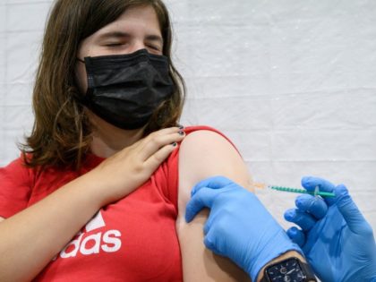 12-year-old Nicole gets her vaccination with the BioNTech vaccine at the district vaccination center in Ludwigsburg, southern Germany, on August 3, 2021, amid the ongoing coronavirus COVID-19 pandemic. - Germany will start offering Covid booster shots from September and make it easier for 12-to-17 year olds to get a jab, …