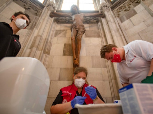 A health worker sitting under a crucifix prepares a syringe at the vaccination center installed at the Barbara Chapel of the famous St Stephen's Cathedral in Vienna on August 11, 2021, amid the novel coronavirus / COVID-19 pandemic. (Photo by ALEX HALADA / AFP) (Photo by ALEX HALADA/AFP via Getty …