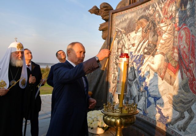 Russian President Vladimir Putin lights a candle unveiling a 50-tonne monument to legendar