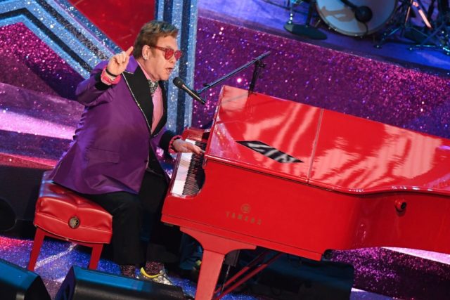 Elton John is performing despite a hip injury that forced him to postpone the rest of his farewell tour dates for this year.