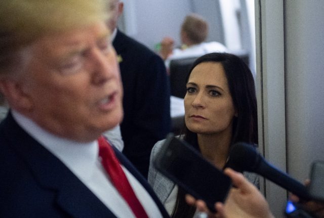 Stephanie Grisham listens as then president Donald Trump speaks to the media aboard Air Fo