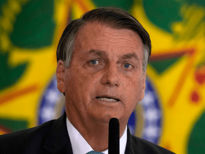 In this Sept. 15, 2021 file photo, Brazilian President Jair Bolsonaro attends a housing program launch ceremony at the Planalto presidential palace, in Brasilia, Brazil. A group of climate lawyers called Tuesday, Oct. 12, 2021 for the International Criminal Court to launch an investigation into Brazil's president for possible crimes …