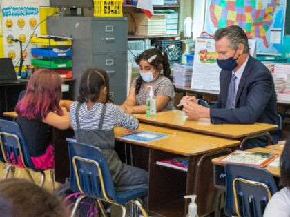 California Gov. Gavin Newsom sits with students of a second grade classroom at Carl B. Munck Elementary School, Wednesday, Aug. 11, 2021, in Oakland, Calif. Gov. Newsom announced that California will require its 320,000 teachers and school employees to be vaccinated against the novel coronavirus or submit to weekly COVID-19 …