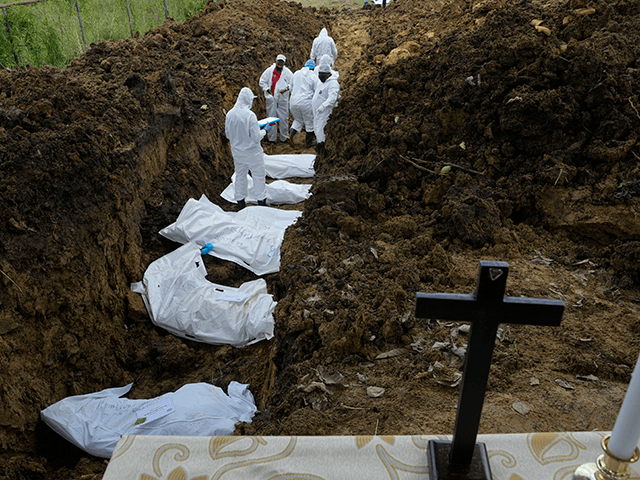 A forensics team bury a group of 15 migrants who died trying to cross the Darien Gap, at the Guayabillo cemetery in Agua Fria, Panama, Thursday, Sept. 30, 2021. The migrants, who are buried with plasticized card containing what little information investigators were able to gather, die of natural causes …