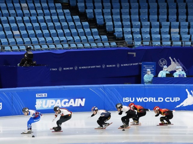 Skaters slide past an empty section of spectator seats while competing in a quarterfinal of the men's 1,500 at the ISU World Cup Short Track speed skating competition, a test event for the 2022 Winter Olympics, at the Capital Indoor Stadium in Beijing, Thursday, Oct. 21, 2021. (AP Photo/Mark Schiefelbein)
