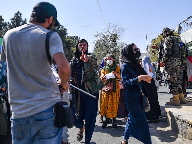 A Taliban members (C) gestures towards journalists covering a women's rights protest in Kabul on October 21, 2021. (Bulent Kilic/AFP via Getty Images)