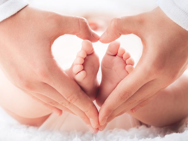 This undated stock photo shows a mother holding a baby's feet in heart shaped hands - infant care concept. An Appeals Court reinstated the Texas Heartbeat Act banning abortion after a heartbeat can be detected.
