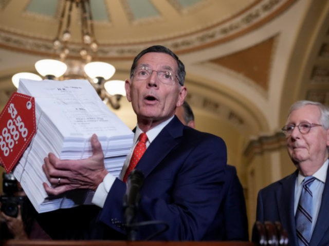 WASHINGTON, DC - SEPTEMBER 28: Senate Minority Leader Mitch McConnell (R-KY) looks on as Sen. John Barrasso (R-WY) holds up a visual aide to represent the Democrats' $3.5 trillion budget reconciliation package as he speaks to reporters after a lunch meeting with Senate Republicans at the U.S. Capitol on September …