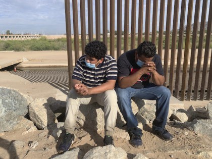 An unidentified migrant father and his son from Honduras wait to be processed after passing through a gap in the border wall in Yuma, Ariz., Wednesday, June 9, 2021 to seek asylum in the US. The Biden administration says it has identified more than 3,900 children separated from their parents …