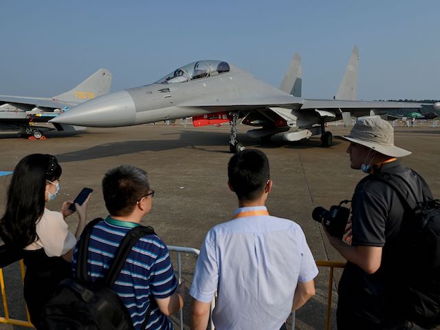 Visitors look at a Shenyang Aircraft Corporation's J-16 multirole strike fighter jet of the People's Liberation Army Air Force (PLAAF) at the 13th China International Aviation and Aerospace Exhibition in Zhuhai in southern China's Guangdong province on September 28, 2021. (Noel Celis/AFP via Getty Images)