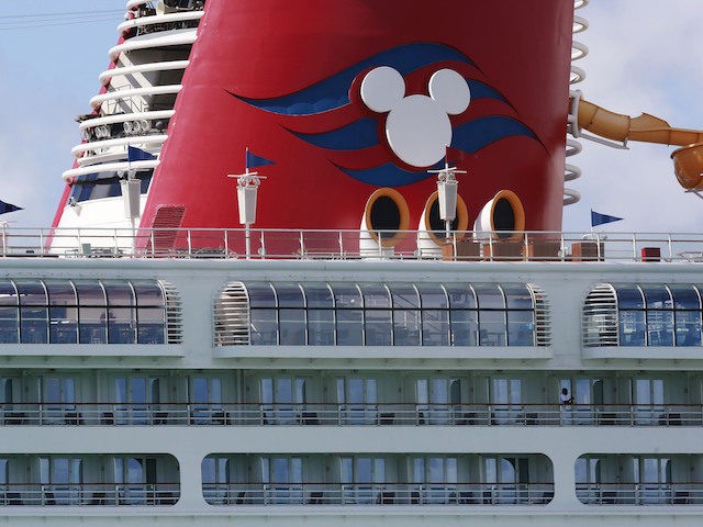 A person leans against the railing of the docked Disney Magic cruise ship at PortMiami ami