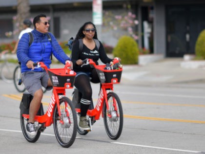 People ride Uber's JUMP e-bikes in car-free streets during a CicLAvia event in Culver City on March 3, 2019. - CicLAvia is a non-profit organization that hosts events where people can bike, walk, skate and stroll on car-free streets. (Photo by Chris Delmas / AFP) (Photo credit should read CHRIS …