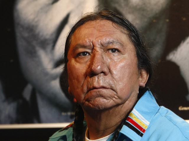 Earnest 'Ernie' LaPointe, the great-grandson of Sitting Bull, is seen front a poster of Sitting Bull in Bremen, northern Germany, Friday, Dec. 12, 2008. The Overseas museum shows an exhibition 'Sitting Bull and his world'. Some 180 exhibits could be seen in Bremen up to May 3, 2008. LaPointe claims to be one of the Sioux chief's closest living descendants.(AP Photo/Joerg Sarbach)