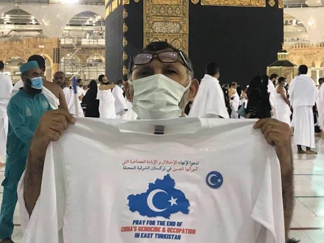Setiwaldi Abdukadir holds up a shirt asking Muslims to pray for Uyghur victims of genocide in China in Mecca, Saudi Arabia, in October 2021.