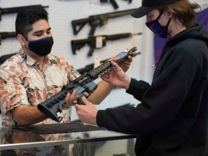 A customer looks at a custom made AR-15 style rifle at Davidson Defense in Orem, Utah on F