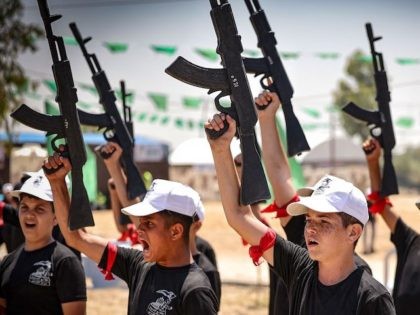 Rafah - Palestinian youths chant slogans as they raise training rifles during a military s