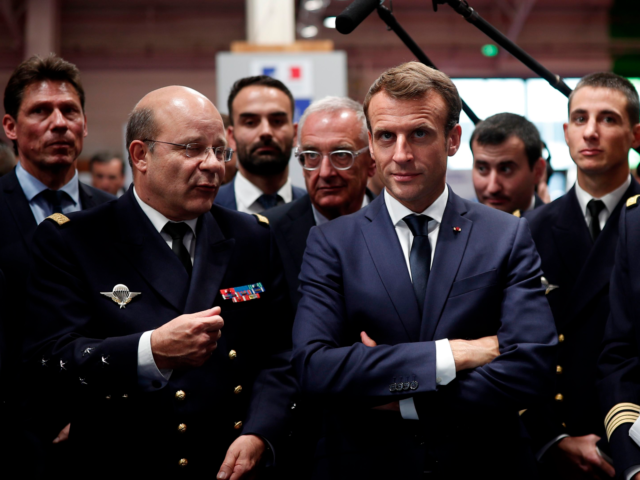 French President Emmanuel Macron (C) looks on as he visits a stand at Euronaval, the world naval defence exhibition in Le Bourget near Paris, on October 23, 2018. (Photo by BENOIT TESSIER / POOL / AFP) (Photo credit should read BENOIT TESSIER/AFP via Getty Images)