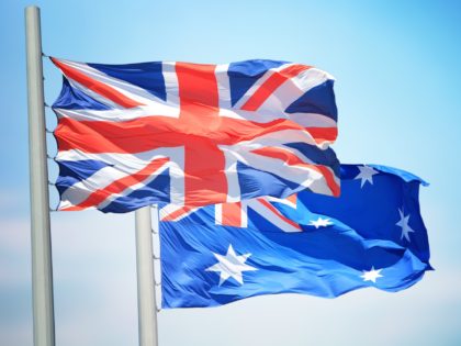 Flags of UK and Australia against the background of the blue sky