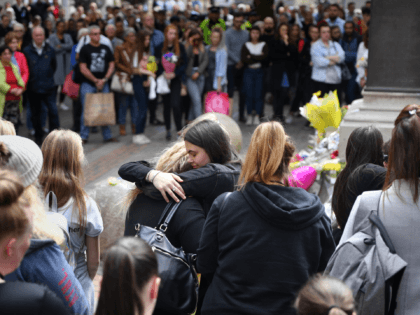 MANCHESTER, ENGLAND - MAY 22: Two women hug during a two minute silence is observed in mem