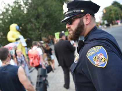 A Baltimore police officer watches as people protest before US President Donald Trump arrives to speak at a fundraising event and the 2019 House Republican Conference Member Retreat Dinner in Baltimore, Maryland on September 12, 2019. (Photo by Eric BARADAT / AFP) (Photo credit should read ERIC BARADAT/AFP via Getty …