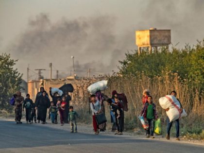 TOPSHOT - Syrian Arab and Kurdish civilians flee with their belongings amid Turkish bombardment on Syria's northeastern town of Ras al-Ain in the Hasakeh province along the Turkish border on October 9, 2019. - Turkey launched a broad assault on Kurdish-controlled areas in northeastern Syria today, with intensive bombardment paving …