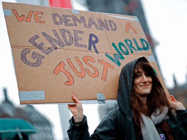 A woman holds a placard as demonstrators attend the "March4Women" during the International Women's Day in London on March 8, 2020. - Many feminist groups held online campaigns instead of street marches, using hashtags such as #FemaleStrike, #PowerUp and #38InternationalWomensDay to raise awareness of gender inequality. (Photo by Tolga Akmen …