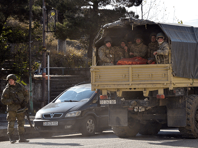 Azerbaijani soldiers ride in the back of a truck through the town of Lachin on December 1,